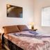 Lower Unit-Yosemite Woods-Inside Yosemite in Yosemite West bedroom with queen bed, lamps and window blinds