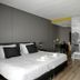 Strandhotel Vigilante room in Makkum with king bed, mural wall, desk and floor lamp