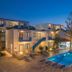 Belvedere Village in Agia Pelagia with lit outdoor pool, loungers, and sunset hillside views