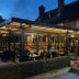 The Carrington Arms in Newport Pagnell, glass-enclosed outdoor dining terrace at dusk