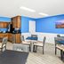 Baymont by Wyndham Forest City breakfast area with coffee station, tables, chairs and bright blue walls