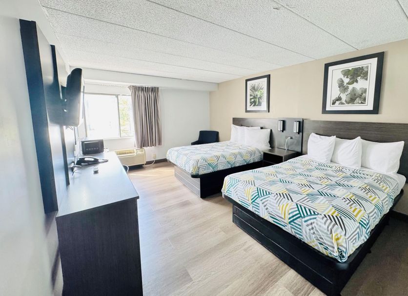 Motel 6 Milford Ct guest room with two beds, TV, and window in Milford