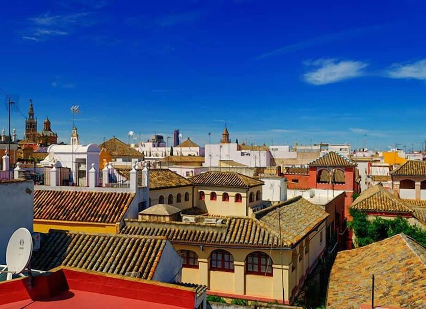 Pension Perez Montilla in Seville with rooftop cityscape and tiled historic rooftops under blue sky