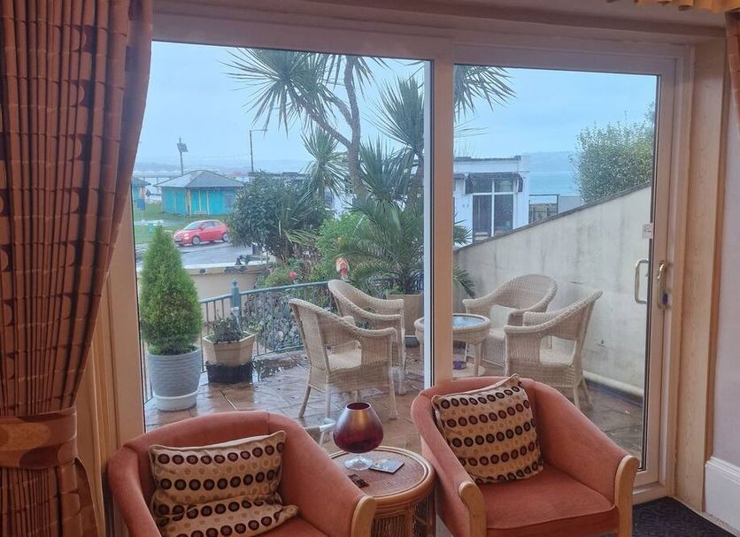 The Sands Hotel, Paignton: sea-view lounge with sliding doors to terrace and coastal view
