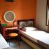 Patria Garden Hotel Blitar twin room with orange wall, desk, and window light