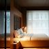 Amadi Park Hotel Amsterdam guest room with king bed, sheer curtains and warm ambient lighting