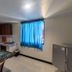 S&C Hotel Suites and Apartments in Koror: apartment-style room with kitchenette, dining table, blue curtains and fridge