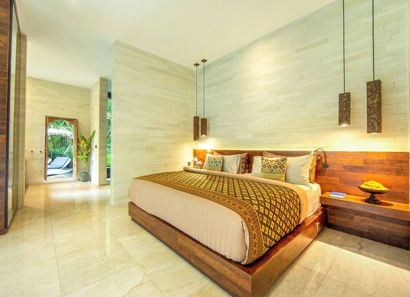 Kelapa Retreat & Spa in Pekutatan features a bright bedroom with a wooden bed and pendant lights