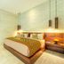 Kelapa Retreat & Spa in Pekutatan features a bright bedroom with a wooden bed and pendant lights