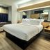 Microtel Inn & Suites by Wyndham Albertville room with king bed, window seat, and desk