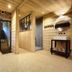 Hotel La Fontaine in Les Houches spa room with sauna, stone wall, and round mirror
