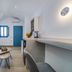 Aegean Blue Suites in Pyrgos Kallistis with blue sofa, kitchenette, and white minimalist interior