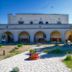 La Piana degli Ulivi in Ostuni with stone arches, courtyard path, and a large tree