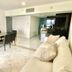 Condo in Ocean Front Resort in Cancún living area with sofa, dining table, wall TV and kitchen