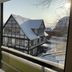 Hotel Martina in Bad Sooden-Allendorf with a balcony view of a snow-covered timber-framed house
