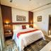 The Lilygate Lagos bedroom with king bed, bedside lamps, patterned rug, and hallway view