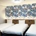 Toyoko Inn Okinawa Naha Asahibashi Ekimae room with three single beds and floral accent wall in Naha