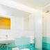 Loft - Hi Eco Hostel Reykjavik bathroom with turquoise tile shower, toilet, and sink