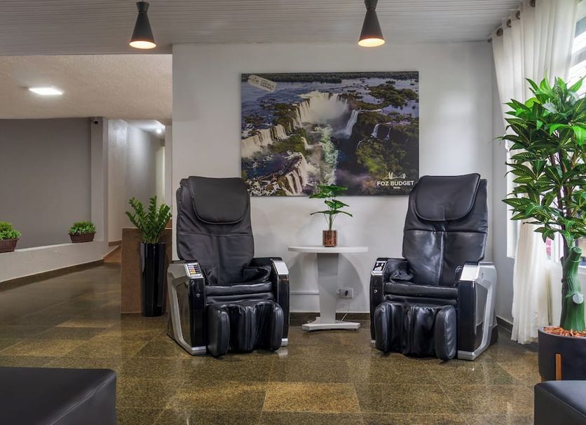 Foz Central Budget Hotel lobby with two massage chairs and a waterfall wall photo in Foz do Iguaçu