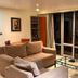 De Vos On The Park Suva living room with sofa and floor-to-ceiling windows overlooking the city