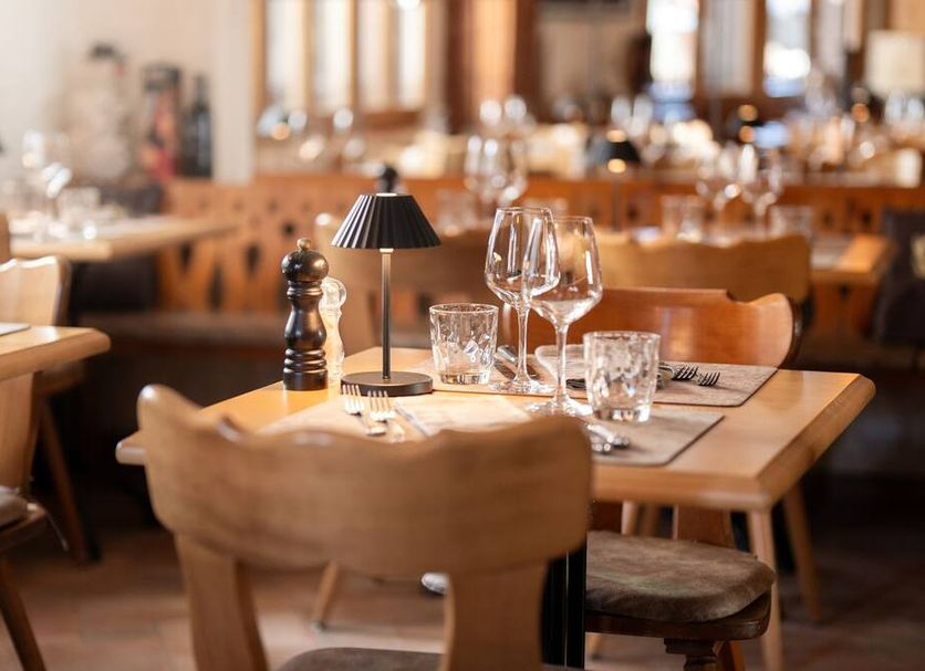 Mazot Zermatt in Zermatt restaurant with wooden tables, set diningware, and warm ambient lighting