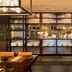 JW Marriott Hotel Hong Kong restaurant interior with open kitchen, shelves of dishes, and set dining tables