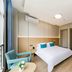 Zhoushan Dinghai New Donggang Hotel guest room with bed, teal chair, and large window in Zhoushan