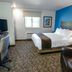 My Place Hotel-Carson City, Nv guest room with queen bed, desk, TV, chair and bright blue accent wall in Carson City