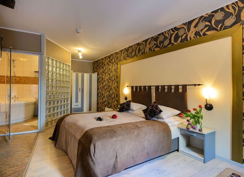 Hansalinn Pärnu hotel room with double bed, glass block bathroom wall and floral wallpaper