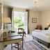 Le Manoir de Gressy guest room in Gressy with twin beds, open balcony doors, and garden view
