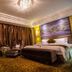 Changchun Huatian Hotel in Changchun guest room with king bed, chandelier, and floor-to-ceiling curtains