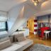 Hotel Villa Klemm Wiesbaden City room with sofa, wood floors, and red bar-style decor wall