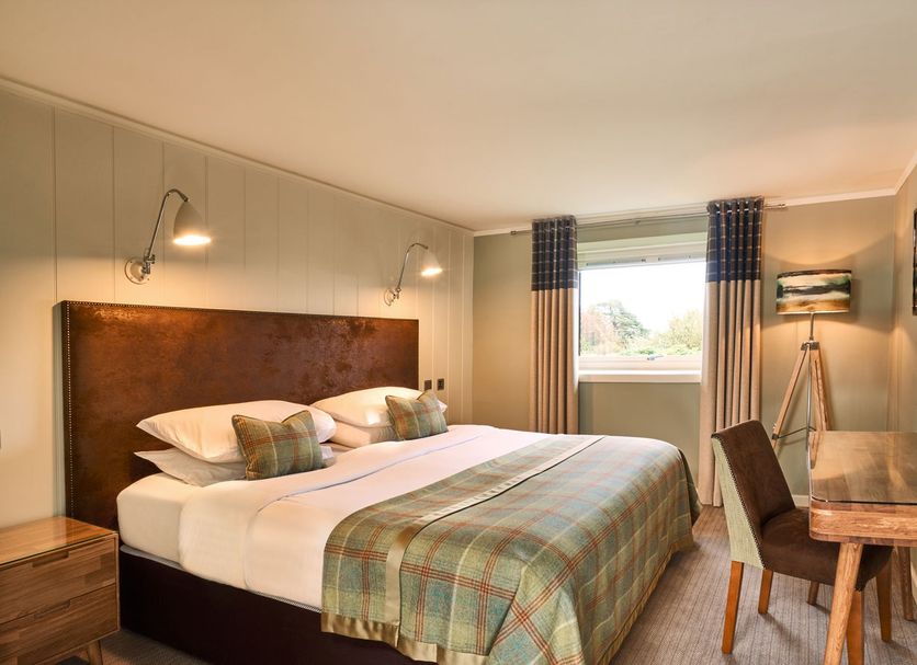 Isle Of Mull Hotel and Spa guest room with king bed, window view, and desk on the Isle of Mull