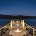 Domes of Elounda, Autograph Collection pier dining table overlooking calm Elounda bay at dusk