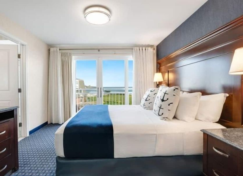 Newport Beach Hotel & Suites Middletown guest room with king bed and balcony ocean view