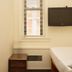 West Village Eurohostel New York room with bed, wall-mounted TV, window blinds and nightstand