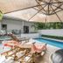 Cove Studios in Byron Bay: private pool deck with loungers, umbrella shade and lush greenery