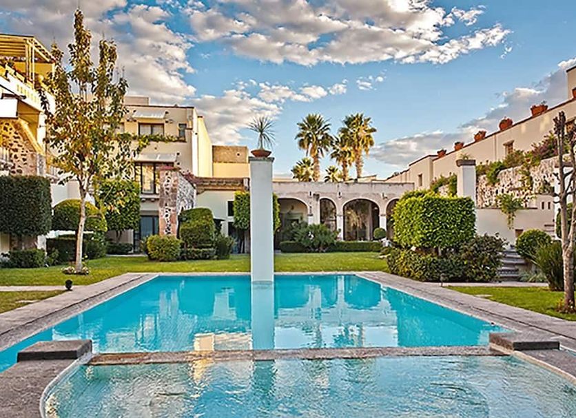 Doña Urraca Hotel & Spa in Santiago de Querétaro with courtyard pool, arches and palm trees