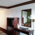 OYO Hotel Kings At Clovis guest room with bed, TV cabinet, desk, mirror and floor lamp in Clovis