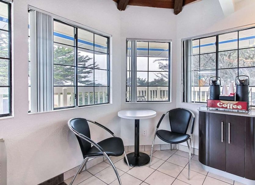 Motel 6 Monterey Marina lobby seating area with bay windows and a coffee station in Marina