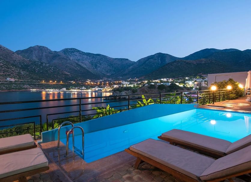 Troulis Apart-Hotel in Bali with infinity pool and mountain and harbor views at dusk