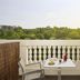 NH Madrid Nacional terrace with table, chairs, potted flowers and green Madrid park views