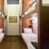 Suneta Hostel Khaosan in Bangkok, compact dorm room with stacked bunk beds and wood-paneled walls