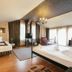 Vila Vidalis Cluj Napoca room with two beds, chandelier, and large windows with sheer curtains