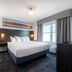 Independence Stay Hotel and Long term suites in Houghton, guest room with king bed and window AC unit