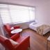 Kosk Sivas in Sivas guest room with two red chairs, single bed, desk, and large window