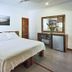 Otro Lado Lodge And Restaurant room in Santa Teresa with king bed, desk, mirror and mini fridge