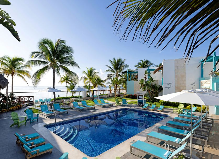 Margaritaville Island Reserve Riviera Cancun in Puerto Morelos, a poolside deck with loungers and ocean view