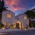 Donatella Boutique Hotel in Miami Beach, white villa facade at dusk with palm trees and glowing windows