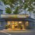 Motel168 Shanghai Qi Bao Inn entrance in Shanghai with lit glass doors and trees outside